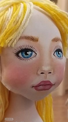 a doll with blonde hair and blue eyes wearing a yellow headband on top of it's head