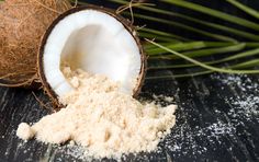 coconuts and powdered sugar are sitting on a wooden table next to palm leaves