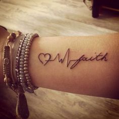 a woman's arm with the word love written on it and two bracelets around her wrist