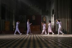 a group of people that are standing in the middle of a room with some lights on