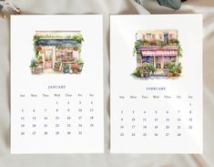 two calendars sitting on top of a bed next to flowers and potted plants