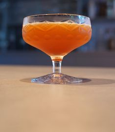 a glass filled with liquid sitting on top of a table