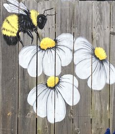 a painting of flowers and a bee on a wooden fence