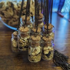 several glass jars filled with different types of food on top of a wooden table next to a bowl of dried herbs