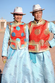 two people standing next to each other wearing hats and clothing with designs on their bodies