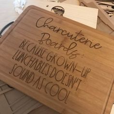 a wooden sign with writing on it sitting on top of a table next to other signs