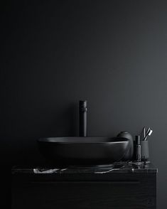 a black bathroom sink sitting on top of a counter