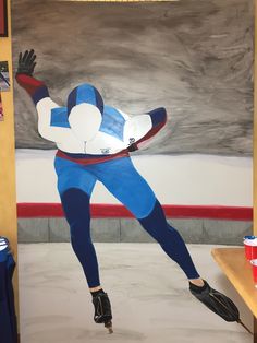 a painting of a man in blue and white is shown on the wall next to a table