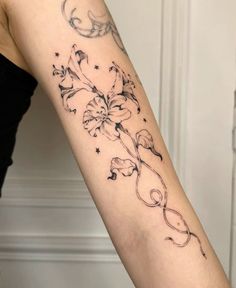 a woman's arm with a flower tattoo on the back of her left arm