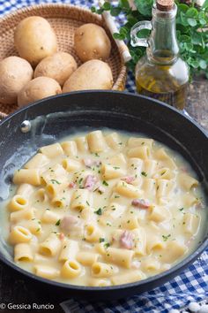 a skillet filled with macaroni and cheese on top of a checkered table cloth