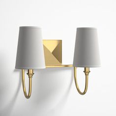 two lamps mounted on the wall next to each other, one light is gold and the other is white