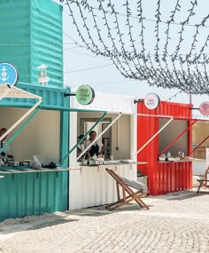 two people are sitting at a small bar made out of shipping containers