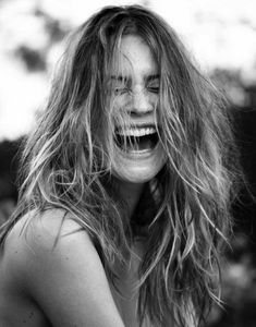 a woman with her mouth open and hair blowing in the wind