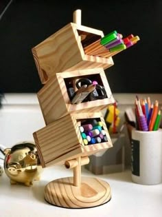 a wooden toy with many different colored pencils and markers in it on a desk