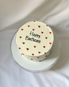 a white cake with red hearts on it and the words happy birthday written on top