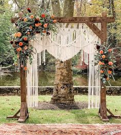 an outdoor wedding ceremony setup with macrame and flowers on the altar, surrounded by greenery