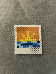 a piece of perler bead art on a gray surface