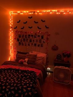 a bed room with a neatly made bed and lots of halloween decorations on the wall