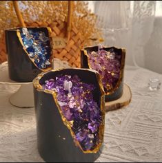 three vases sitting on top of a table covered in purple and gold flakes