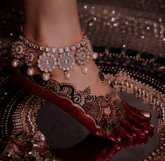 a close up of a person's foot with jewelry on it