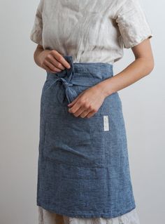 a woman is wearing an apron with a tie around her waist