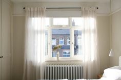 a bedroom with a radiator, bed and window