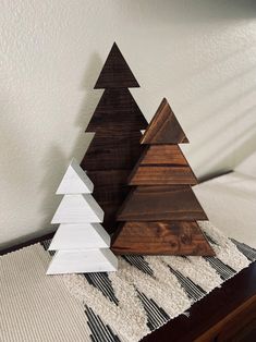 three wooden christmas trees sitting on top of a bed