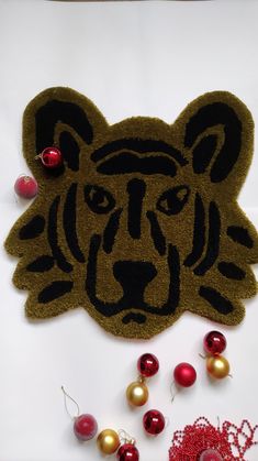 a door mat with a tiger face on it and ornaments around it in front of the door