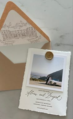 an open envelope with a wedding photo on it and a wax stamp attached to the front