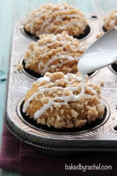 a muffin tin filled with cupcakes covered in icing and crumbs