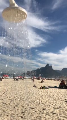 people are on the beach with umbrellas in the air and water coming out of their heads