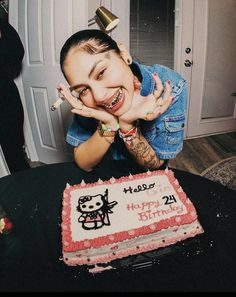 a woman is posing in front of a birthday cake