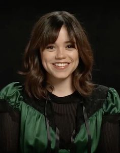 a smiling woman in a green blouse and black shirt