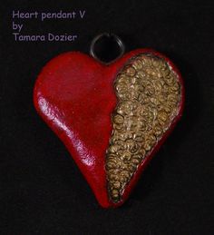 a red heart shaped pendant with gold flakes on it's side and the words i love you