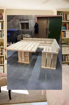 a table made out of wooden pallets in front of bookshelves and a bed