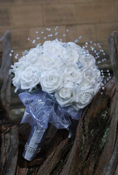 a bridal bouquet sitting on top of a tree stump