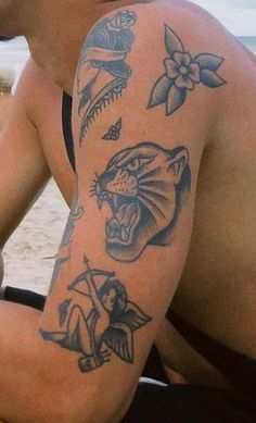 a man sitting on the beach with tattoos on his arm