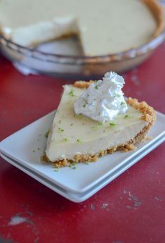 a piece of pie sitting on top of a white plate next to a glass bowl