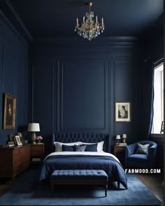 a bedroom with dark blue walls and a chandelier hanging from the ceiling, along with an upholstered bed