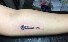 a tattoo on the arm of a woman with a microphone in it's ear