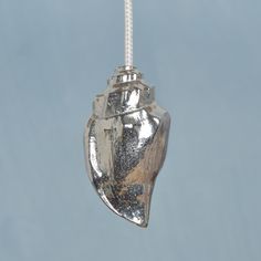 a silver object hanging from a string on a blue sky background in the shape of a heart