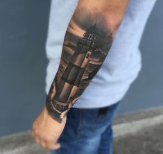 a man with a lighthouse tattoo on his arm