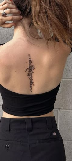 a woman with a cross tattoo on her back