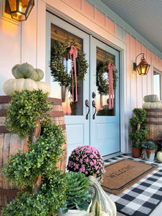 front porch decorated for fall with pumpkins and gourds