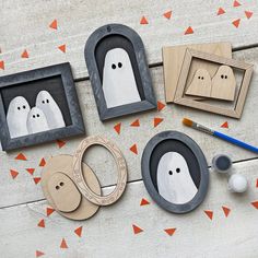 three wooden frames with ghost faces on them and some other items to make it look like they're ready for halloween