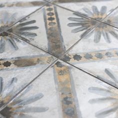 an old tile floor with decorative designs on it