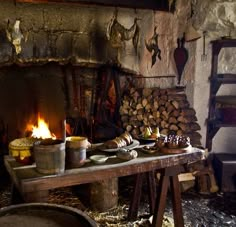 an old fashioned kitchen with wood burning in the fireplace and various cooking utensils