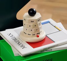 a stack of books sitting on top of each other next to a book with a black button