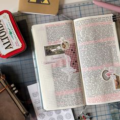 an open book sitting on top of a table next to some scissors and other items