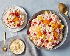 a bowl of fruit salad next to two bowls of oatmeal